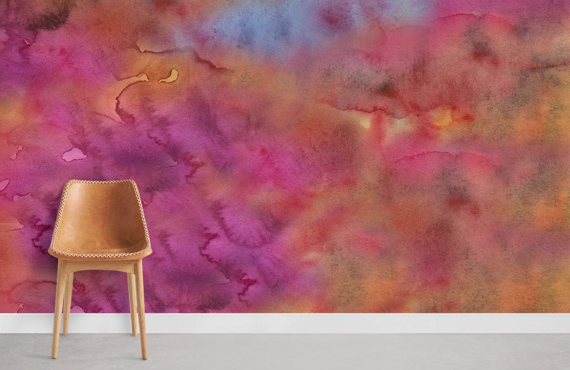 Vibrant watercolour floral mural wallpaper in pink, orange, blue tones with a brown leather chair.