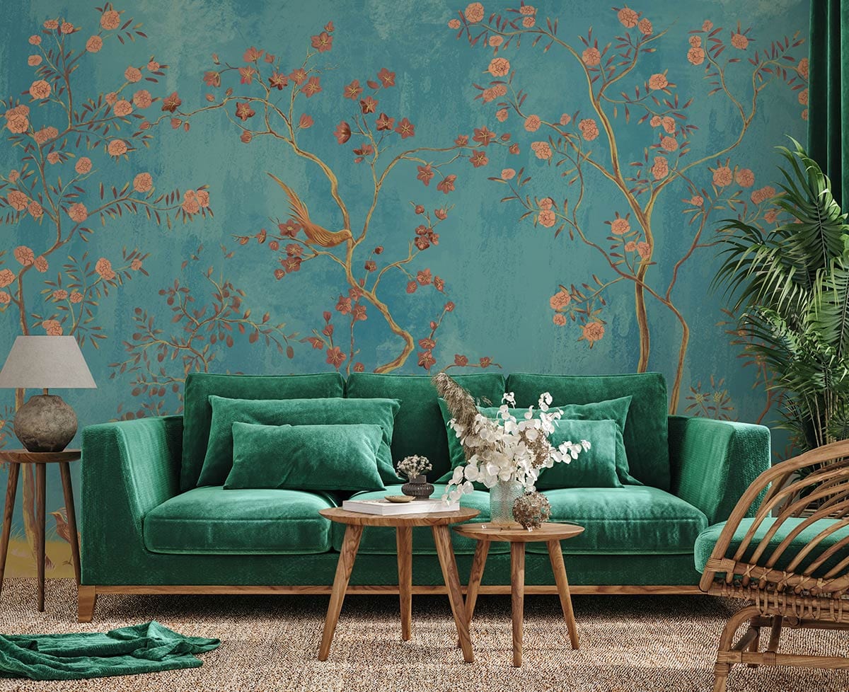 Elegant turquoise floral mural wallpaper with birds, pink blossoms, green velvet sofa, wooden tables, rug.