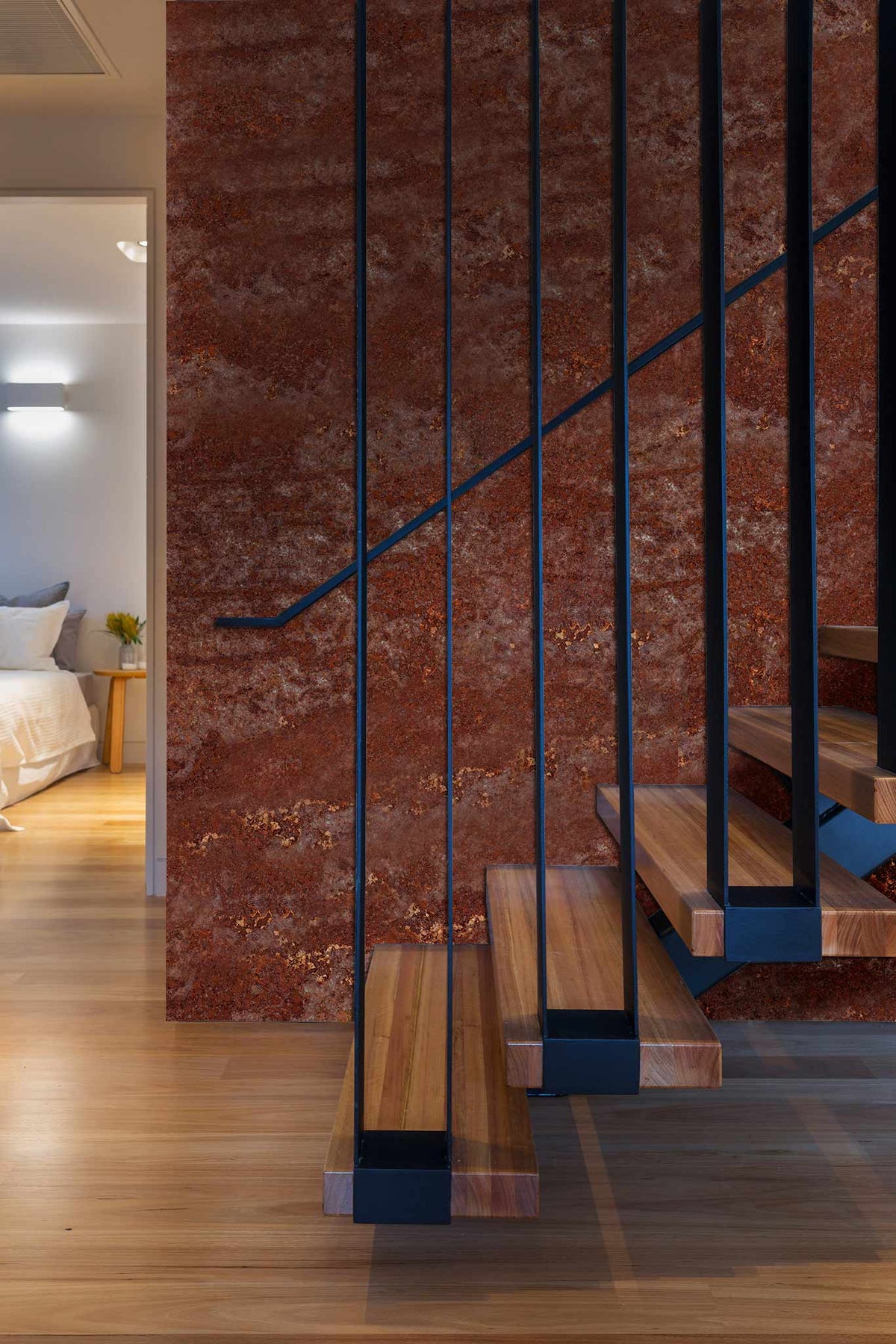 Rustic earthy tones textured brown wallpaper with modern staircase, wooden flooring, bedroom view.
