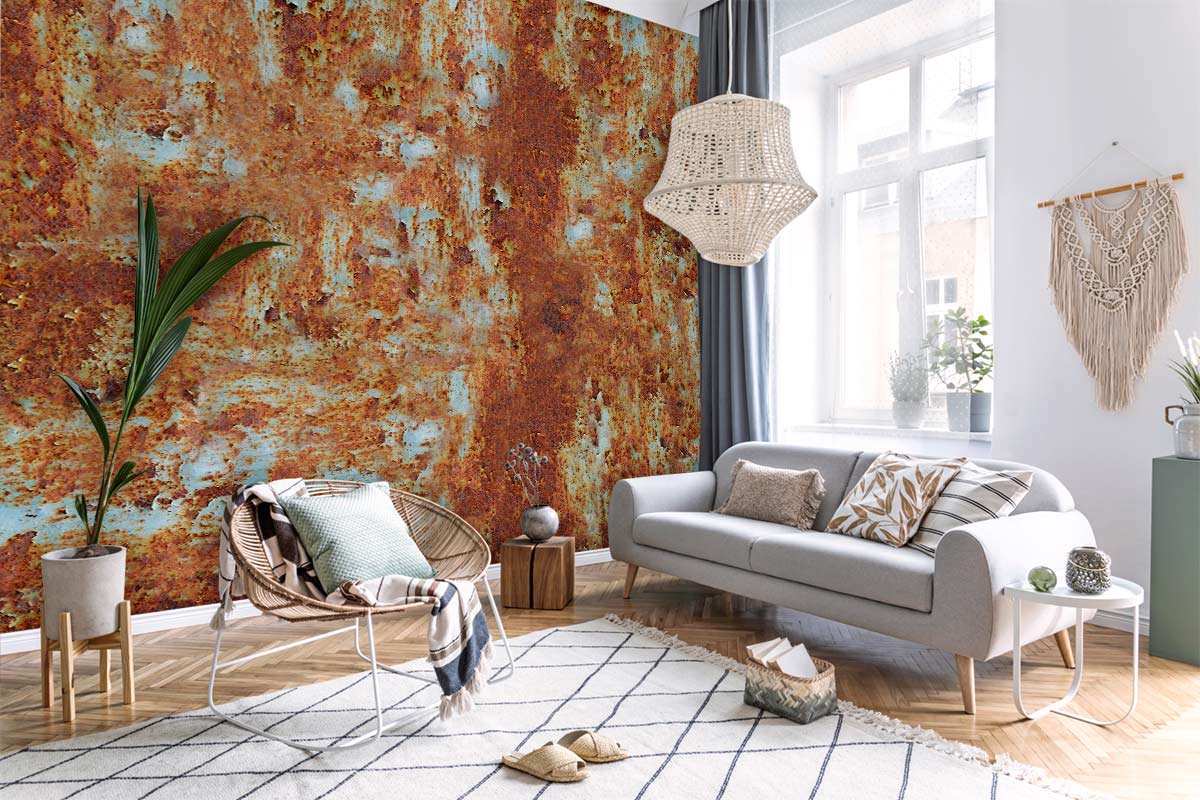 Vintage rust industrial mural wallpaper, grey sofa, wicker chair, wooden flooring, airy modern living room.