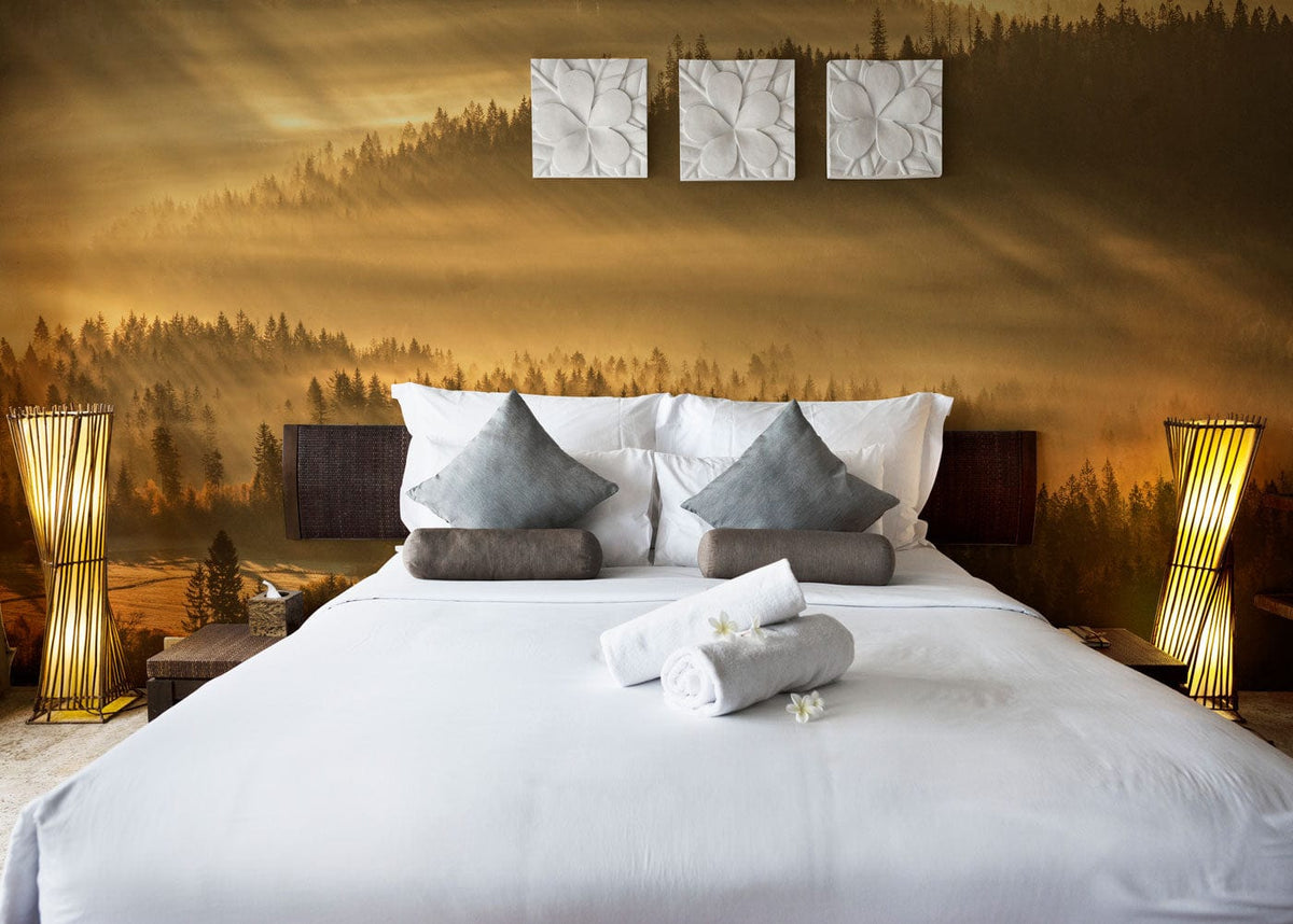 Golden Misty Forest Sunrise mural in bedroom, white bed, grey cushions, wooden nightstands, nature-inspired Décor.