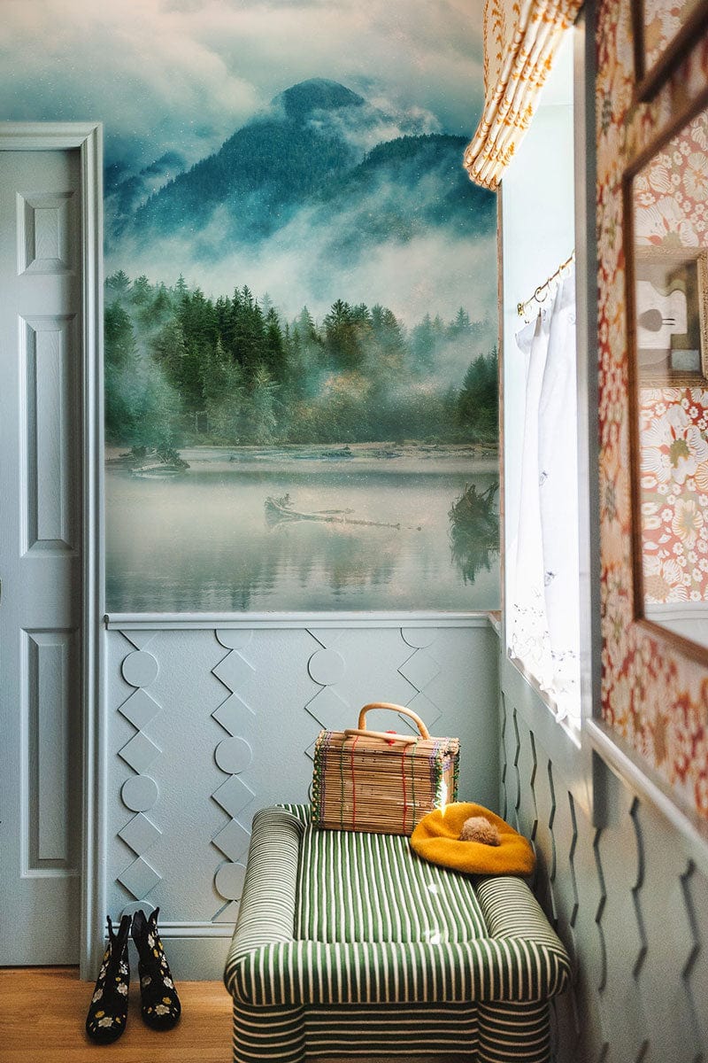 Serene Misty Mountain mural in cosy hallway with striped bench, patterned walls, and blonde wood flooring.