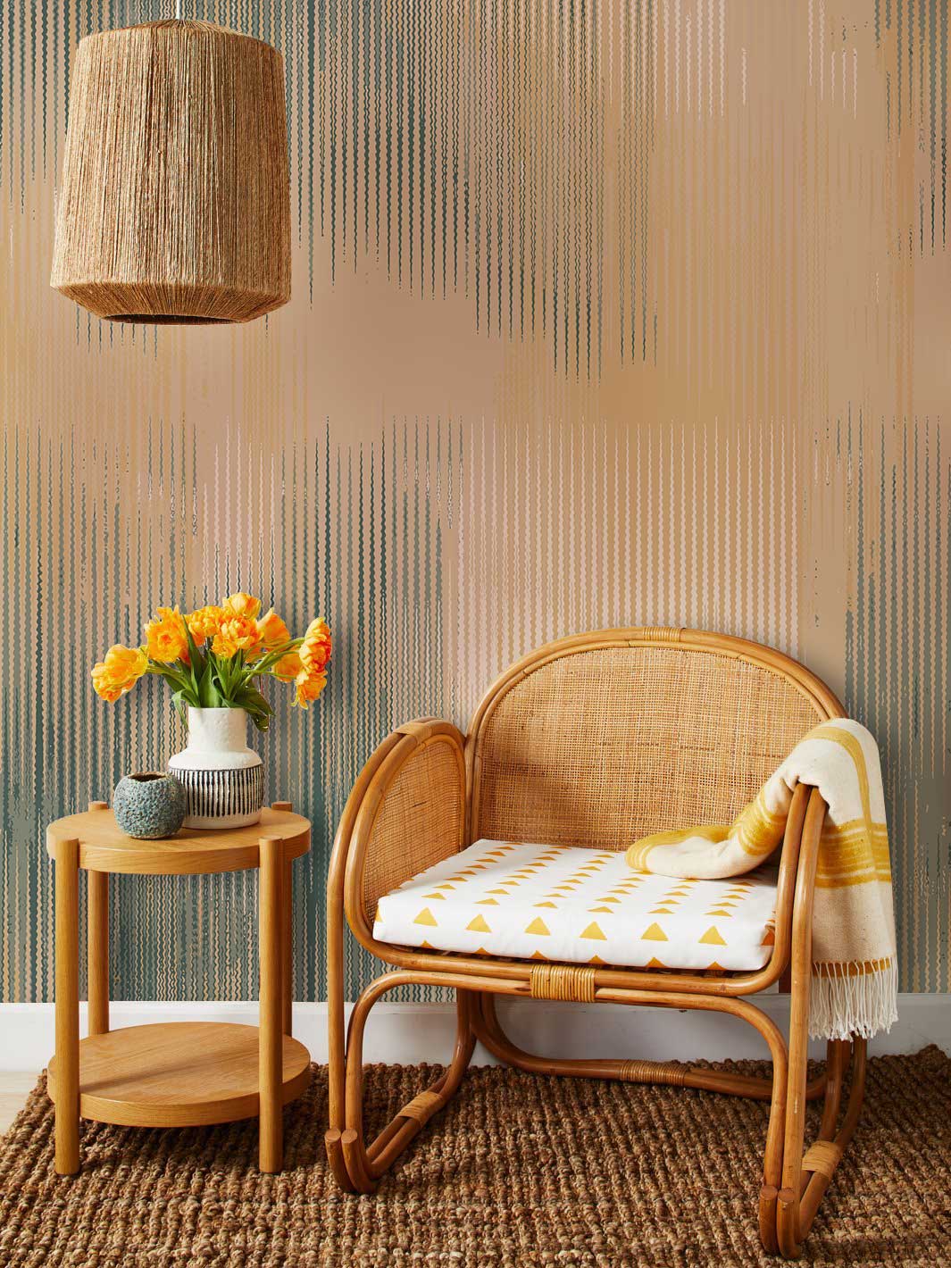 Serene Abstract Striped Wallpaper in earthy tones complements rattan chair, woven lamp, and jute rug.