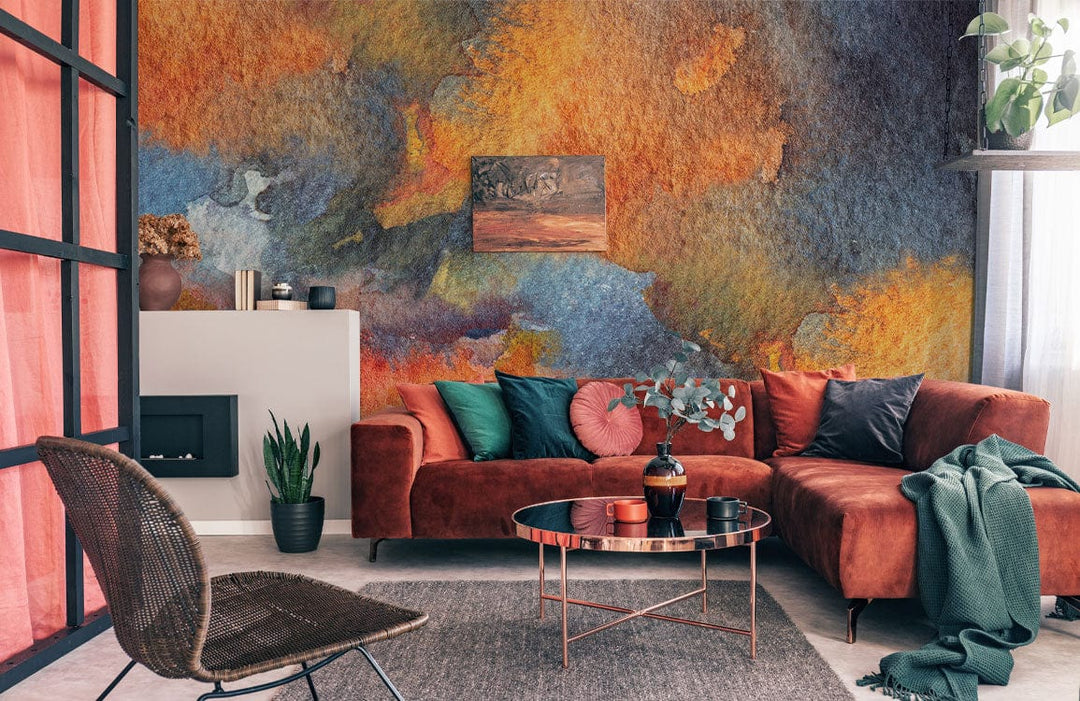 Abstract watercolour mural wallpaper with vibrant autumnal hues, rust velvet sofa, lounge setting, modern decor.