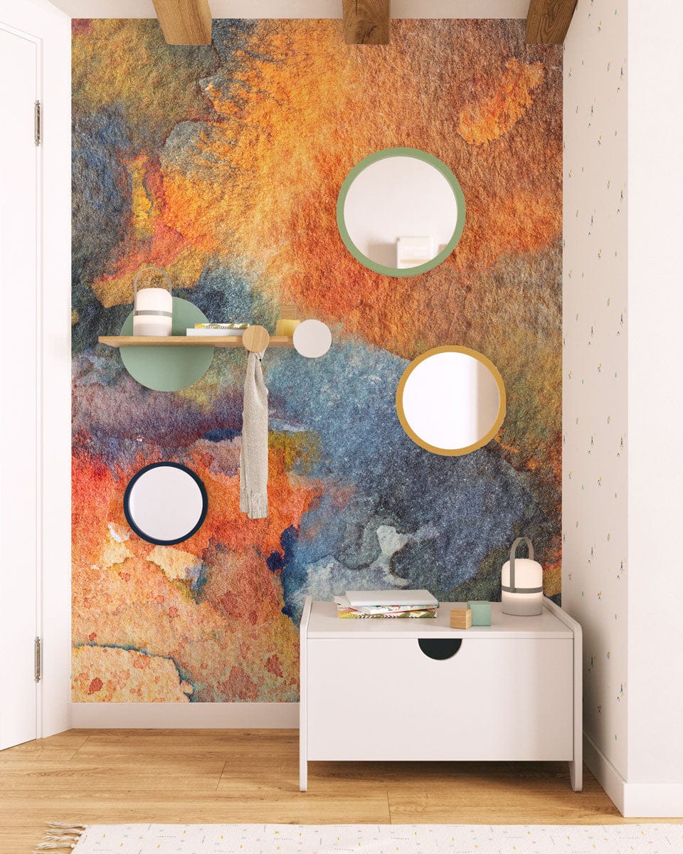 Abstract watercolour mural wallpaper, vibrant autumnal hues, white chest, natural wood flooring, modern mirrors.