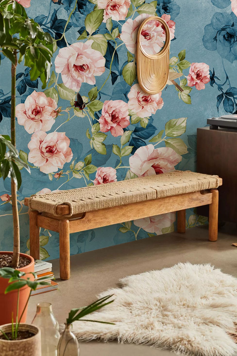 Vintage floral wallpaper with blue-pink roses, wooden bench, mirror; cosy room with soft rug.
