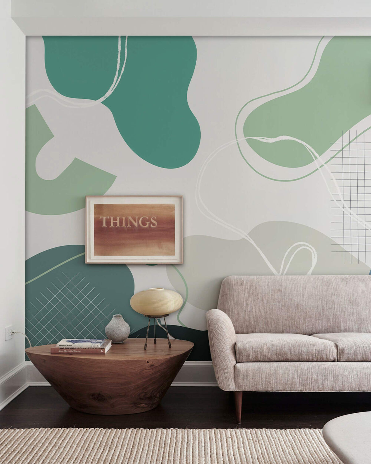 Abstract green and teal geometric mural wallpaper with beige sofa, wooden table, modern living room.
