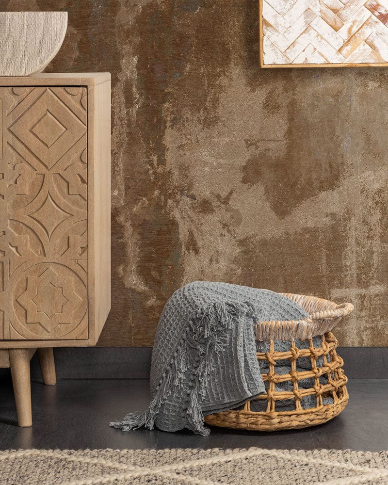 Abstract rustic brown and beige mural wallpaper in vintage room with wicker basket and wooden cabinet.