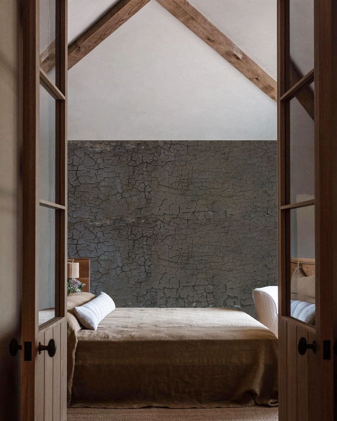 Vintage rustic crackle effect wallpaper in bedroom with beige sofa, wooden beams, and modern decor.