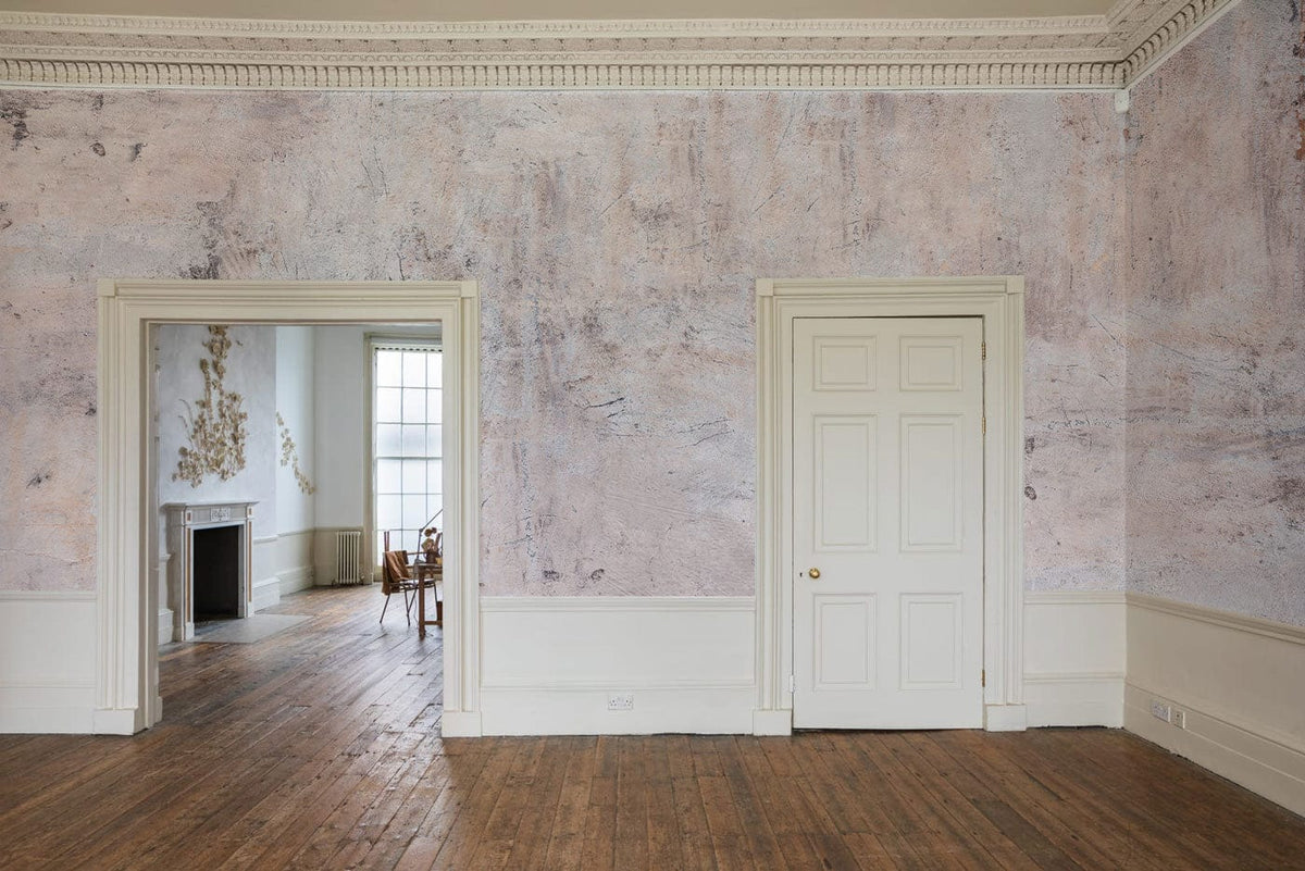 Abstract vintage textured mural wallpaper in living room with wooden flooring and neutral wall trim.