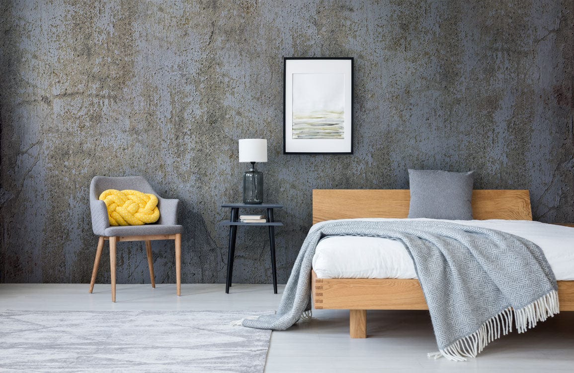 Vintage industrial grey concrete mural wallpaper in modern bedroom with wooden bed, grey chair, and rug.