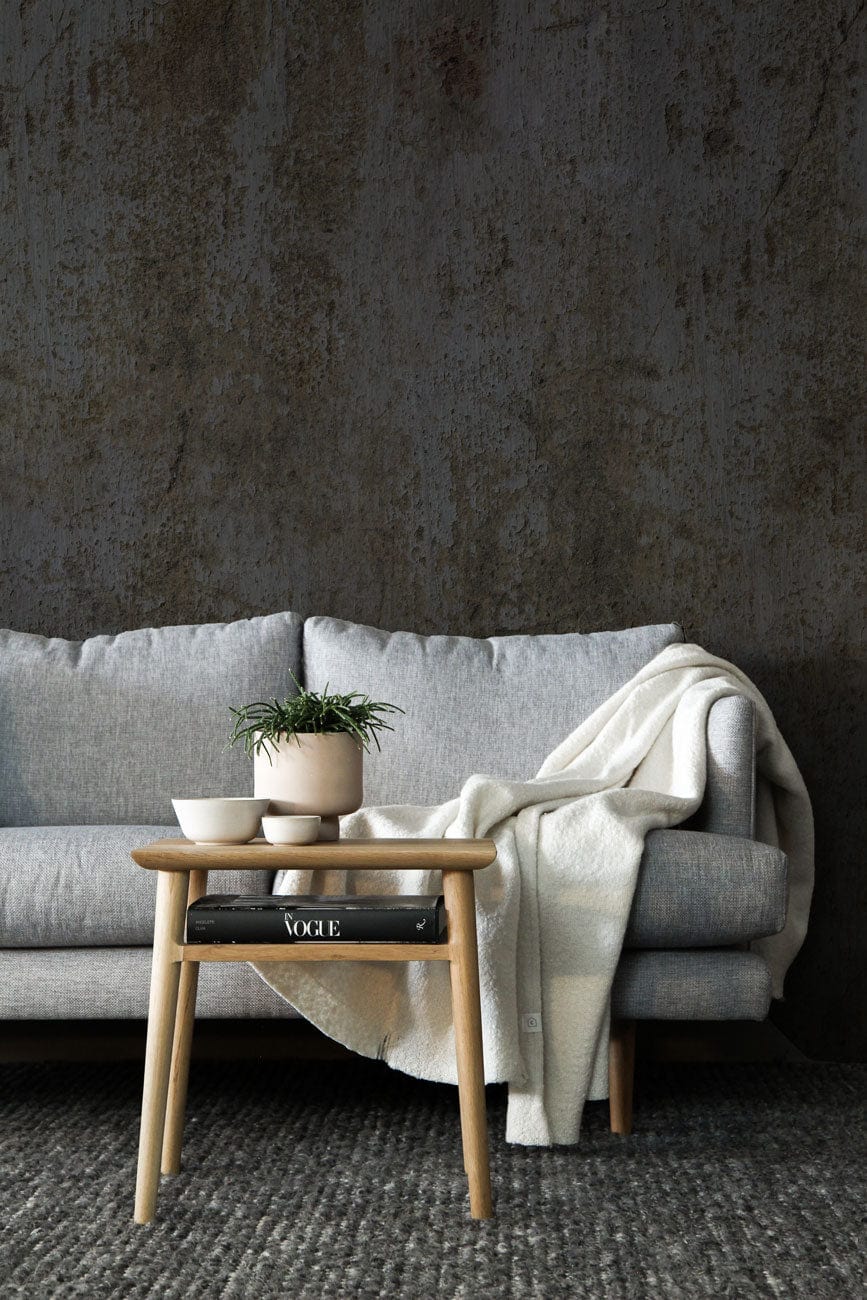 Vintage Industrial Grey Concrete Mural Wallpaper, grey sofa, wooden coffee table, and textured carpet flooring.