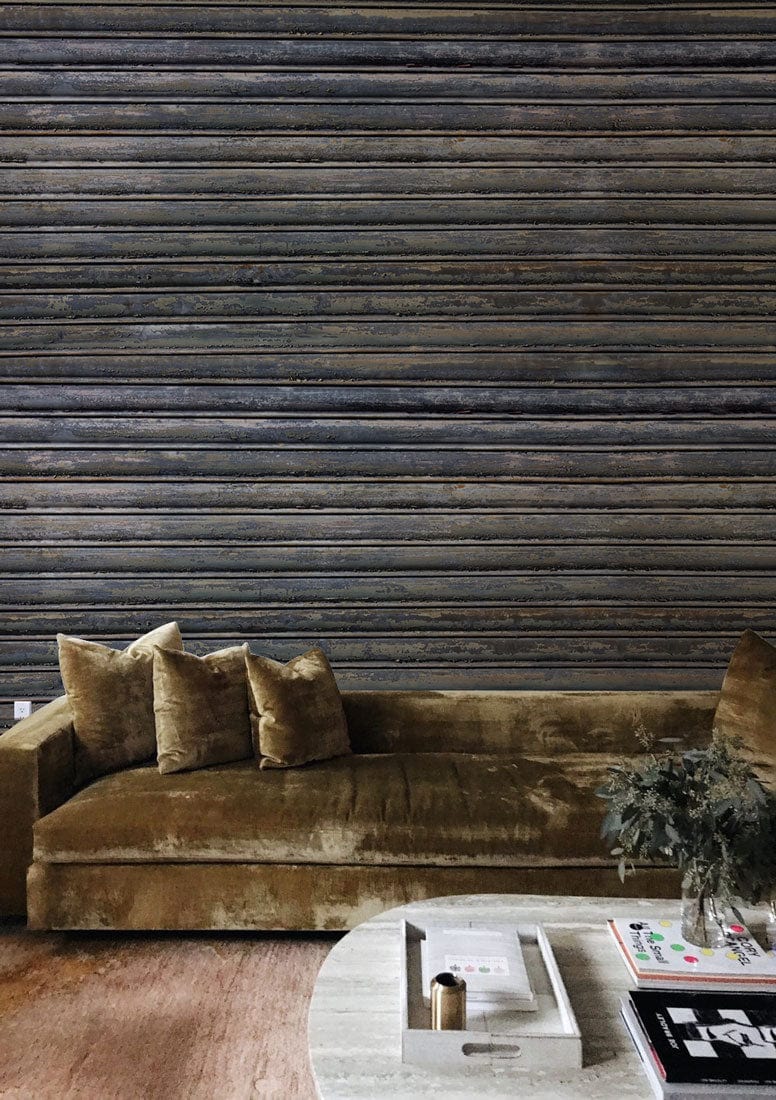 Rustic industrial grey weathered metal wallpaper in living room, brown velvet sofa, round coffee table.