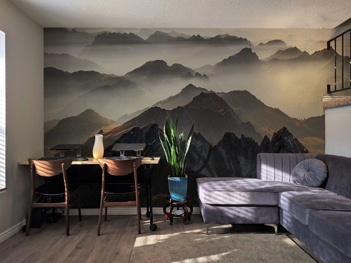 Living room with Misty Mountain Range Scenic Wallpaper Mural, grey sofa, wooden chairs, light flooring.