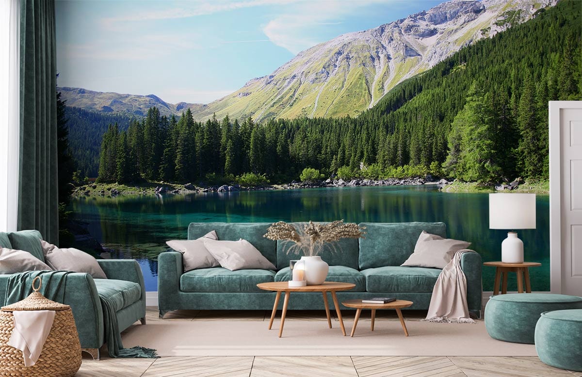 Alpine lake landscape wallpaper with teal sofas, wooden tables, in a cosy, carpeted living room.