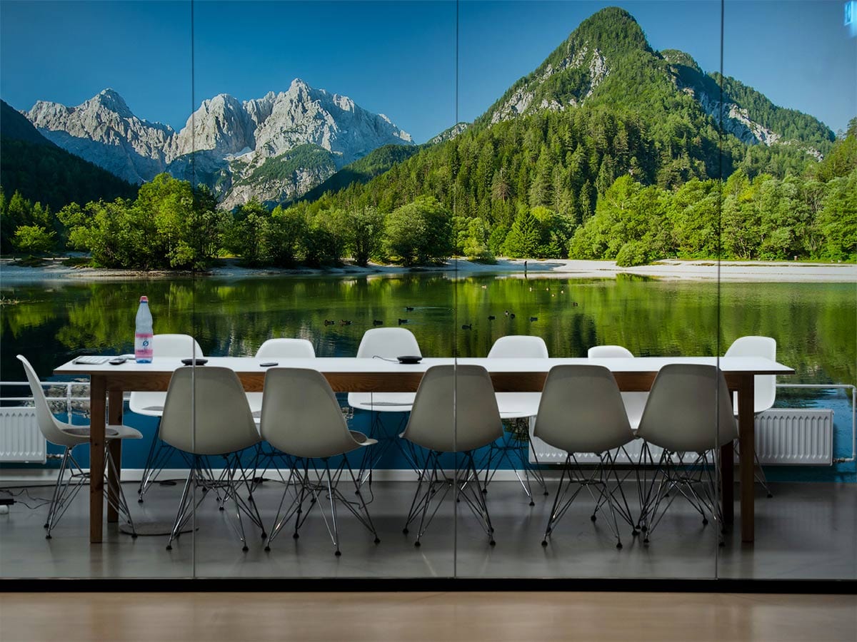 Alpine lake mural wallpaper in dining room with white chairs, wooden table, and wooden flooring.