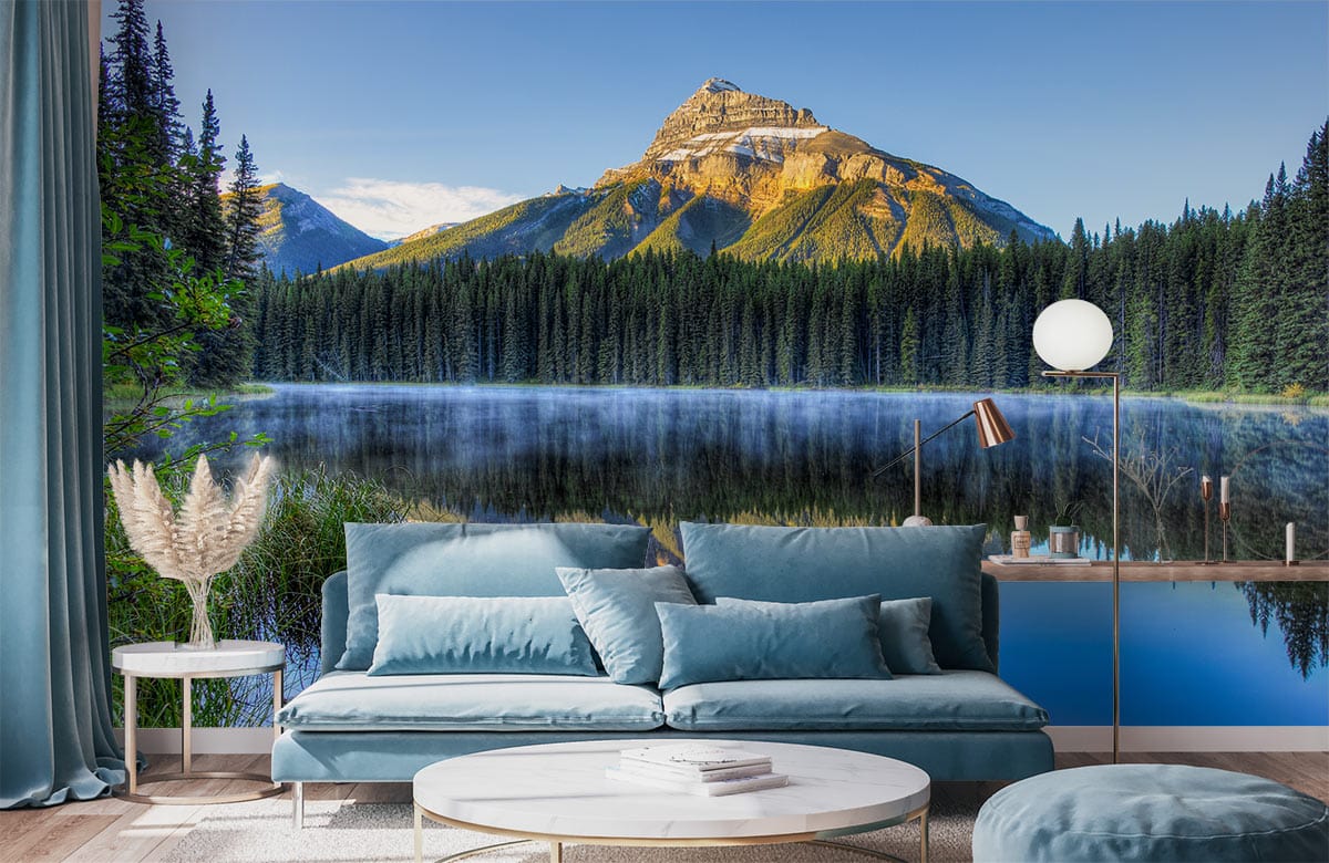 Blue and green mural wallpaper featuring mountain reflection, blue sofa, round white table, and lamp.