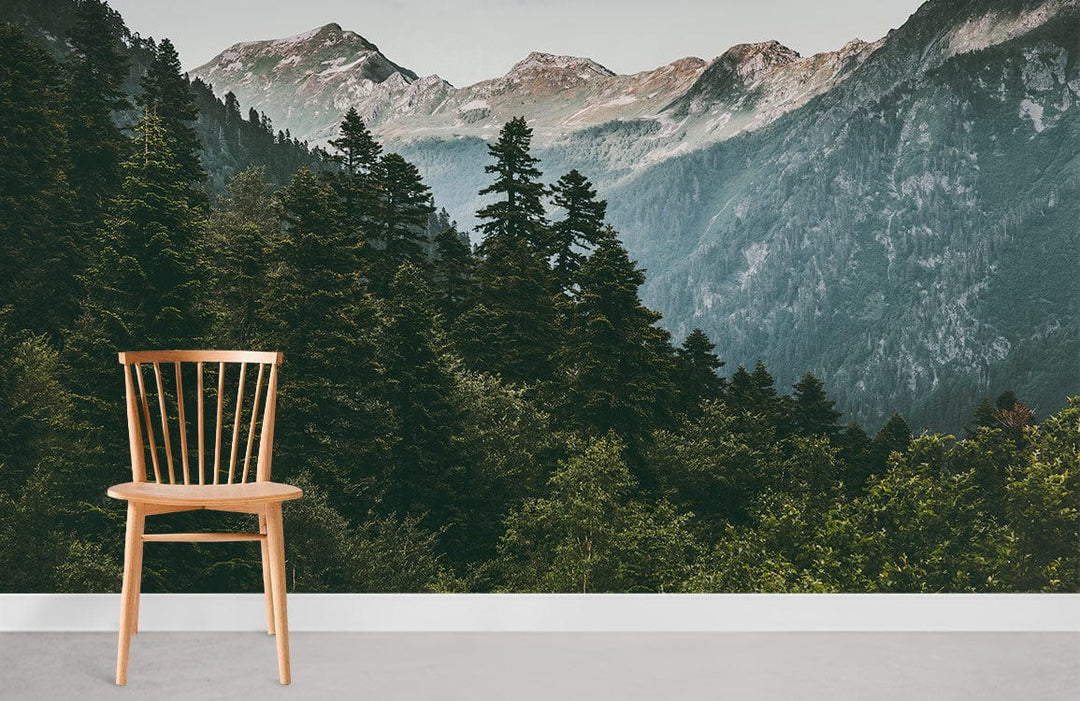 Chair in room with Serene Mountain Forest Mural Wallpaper: lush green landscape; grey flooring.