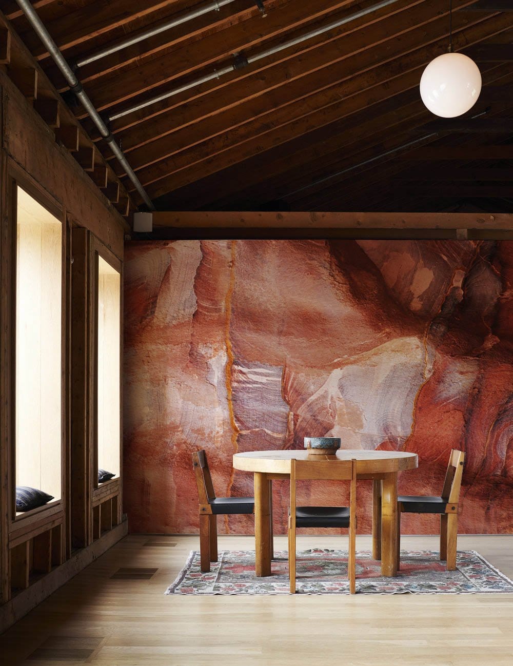 Rustic Terracotta Abstract Stone Texture Mural Wallpaper in dining room with wooden table, rug, wooden flooring.