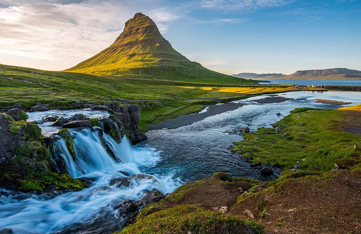 Breathtaking Mountain Landscape Mural Wallpaper with Lush Greenery and Waterfall Scene.