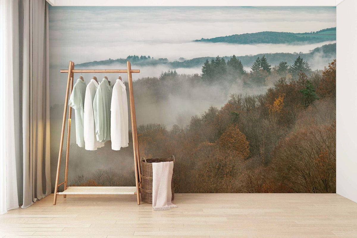 Misty Autumn Forest mural wallpaper in minimalist room with light wood flooring and simple clothes rack.