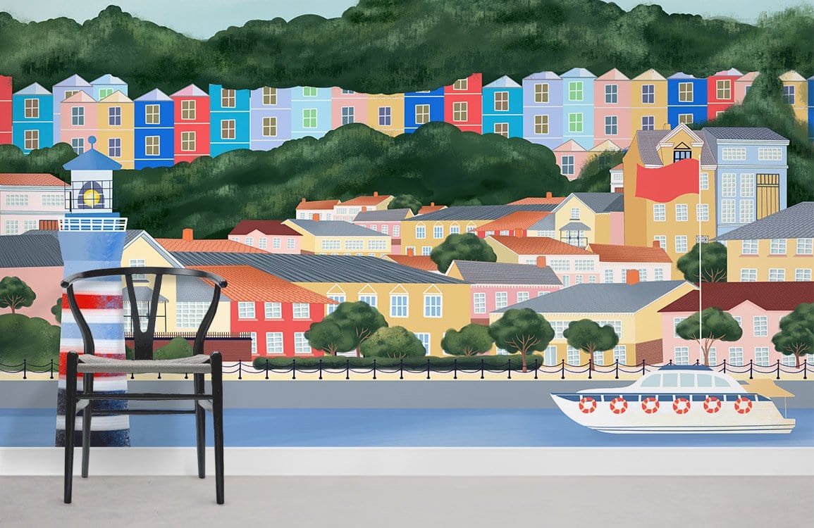 Scenic coastal town mural wallpaper featuring colourful houses, black chair, light grey flooring in living room.