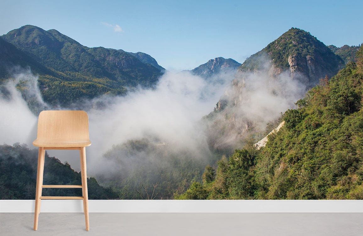 Serene Mountain Landscape Mural Wallpaper with wooden chair, grey flooring, blue-green mountains, misty atmosphere.