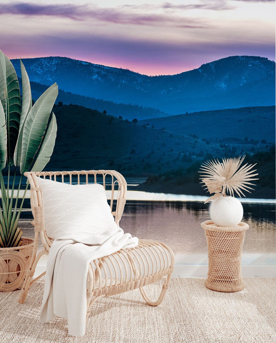 Tranquil Mountain Dusk wallpaper mural, rattan chair, neutral textured rug, potted greenery in serene setting.