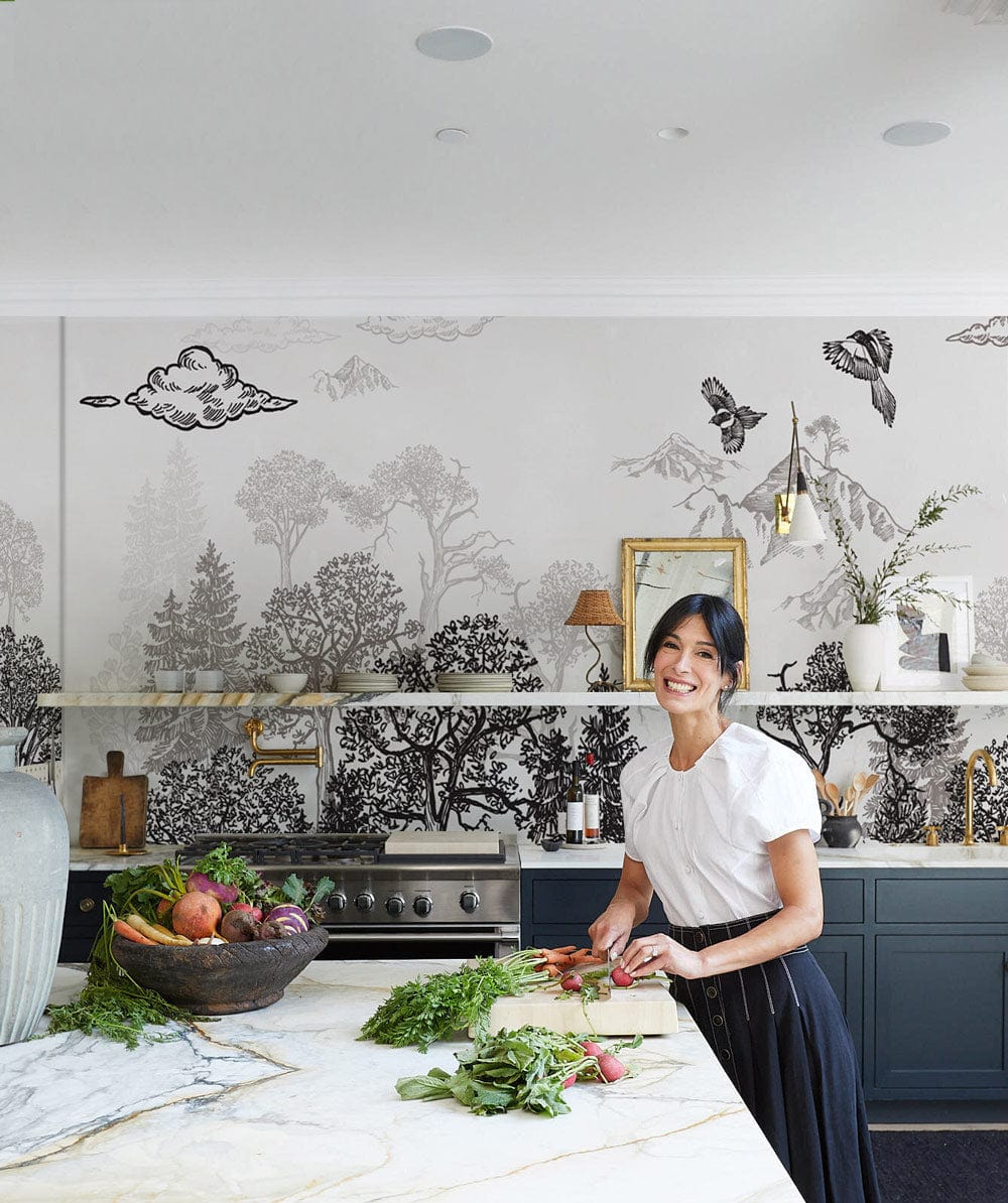 Monochrome woodland wallpaper in elegant kitchen, marble countertops, dark cabinets, chic decor, brand unknown.