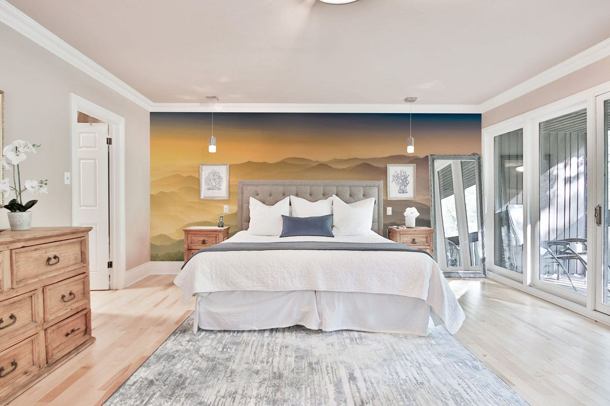 Tranquil Sunrise Mist Mountain Wallpaper in bedroom with wooden furniture, white bedding, light wood flooring.