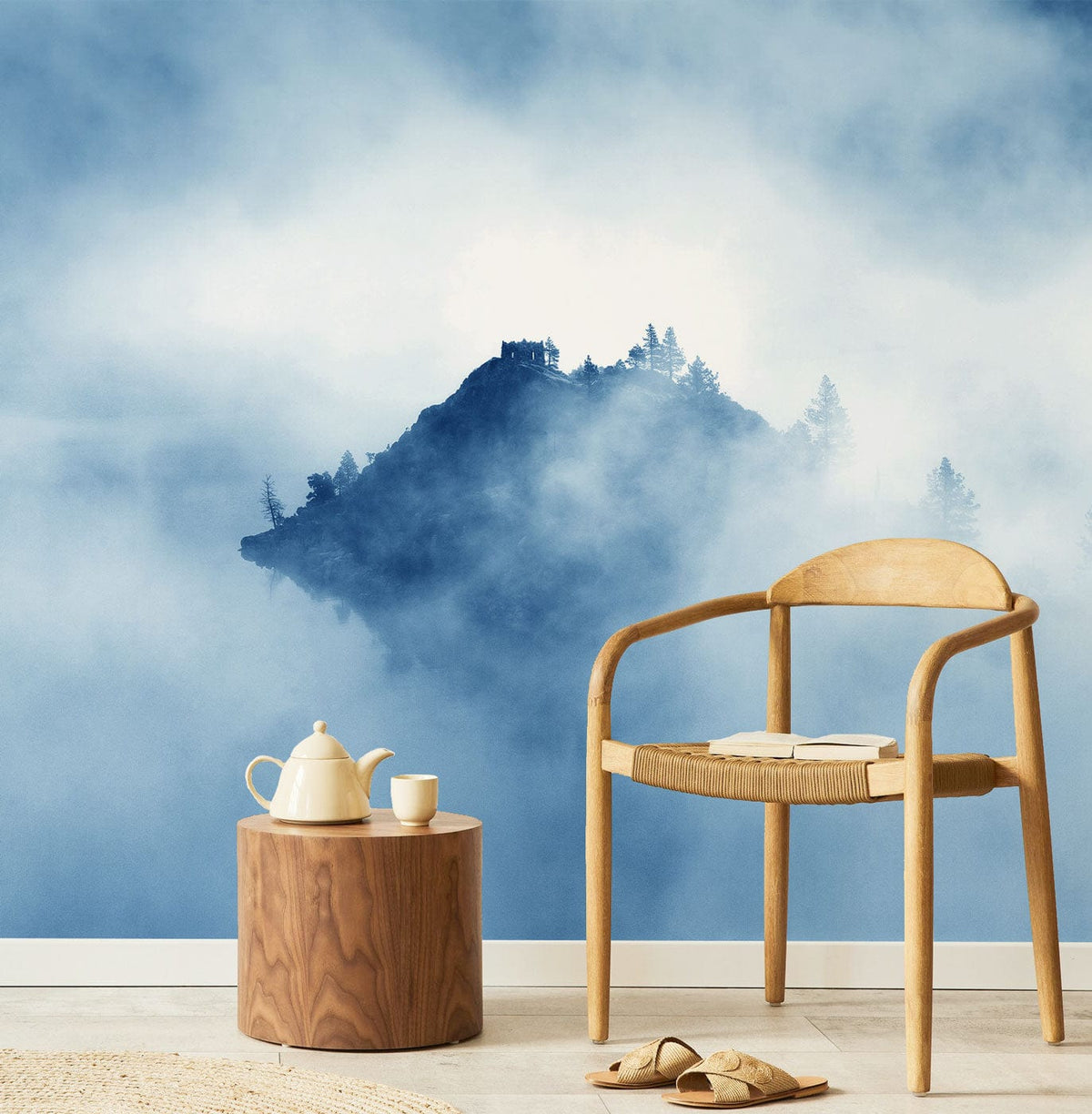 Misty Blue Mountain Landscape Mural Wallpaper with wooden chair, minimalist decor, light flooring.