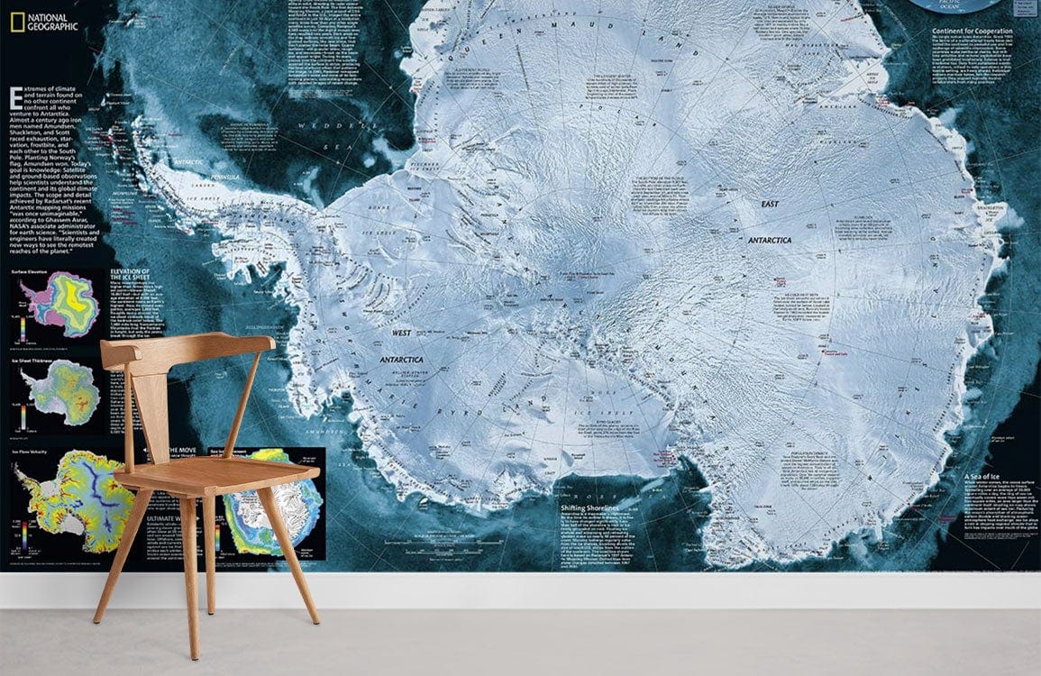 Antarctica exploration map mural wallpaper with wooden chair; detailed blue design by National Geographic.