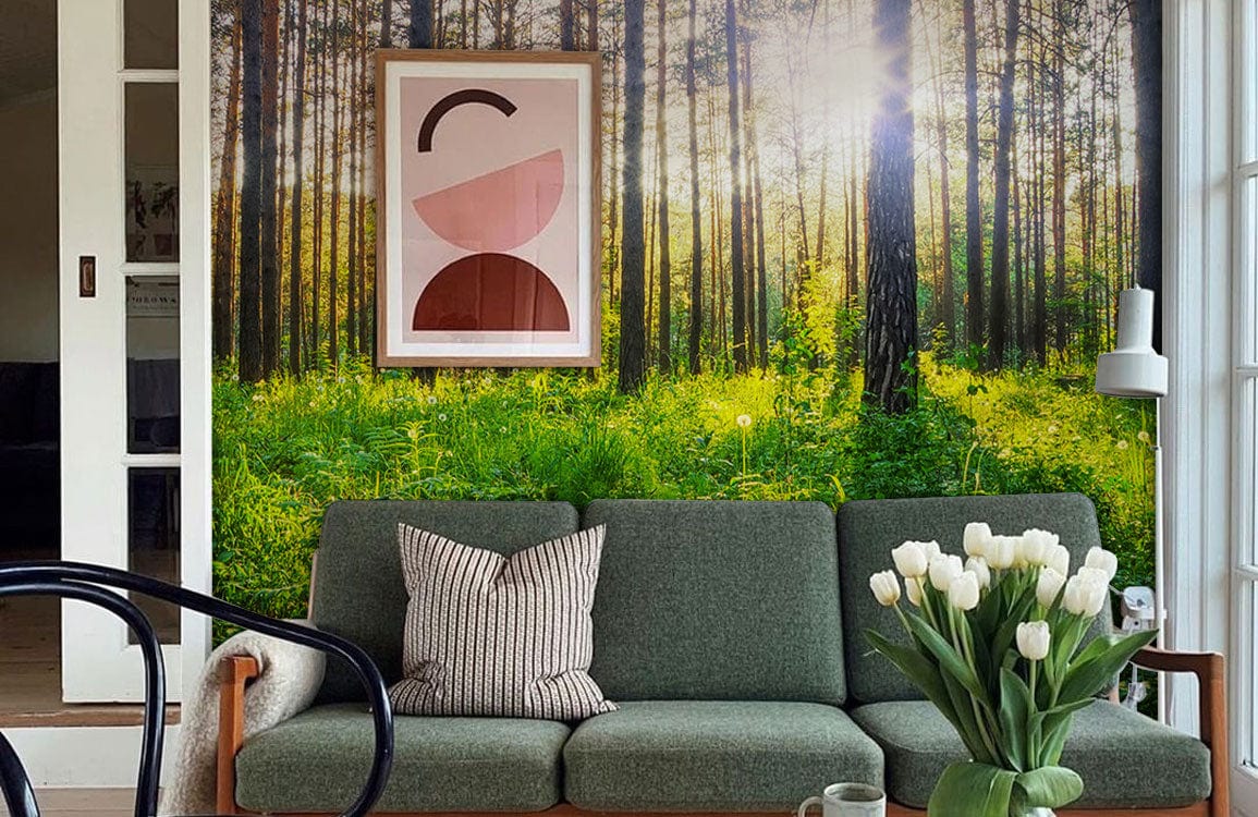Sunlit forest mural with green sofa, modern art, white tulips; cosy living room design.