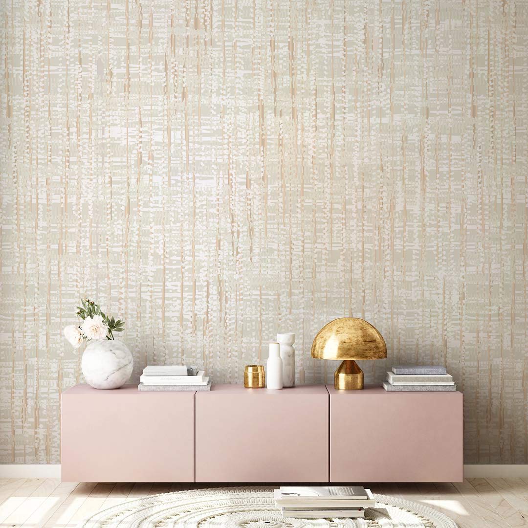 Beige textured linen-effect wallpaper in stylish living room with pink sideboard and decorative lamp.