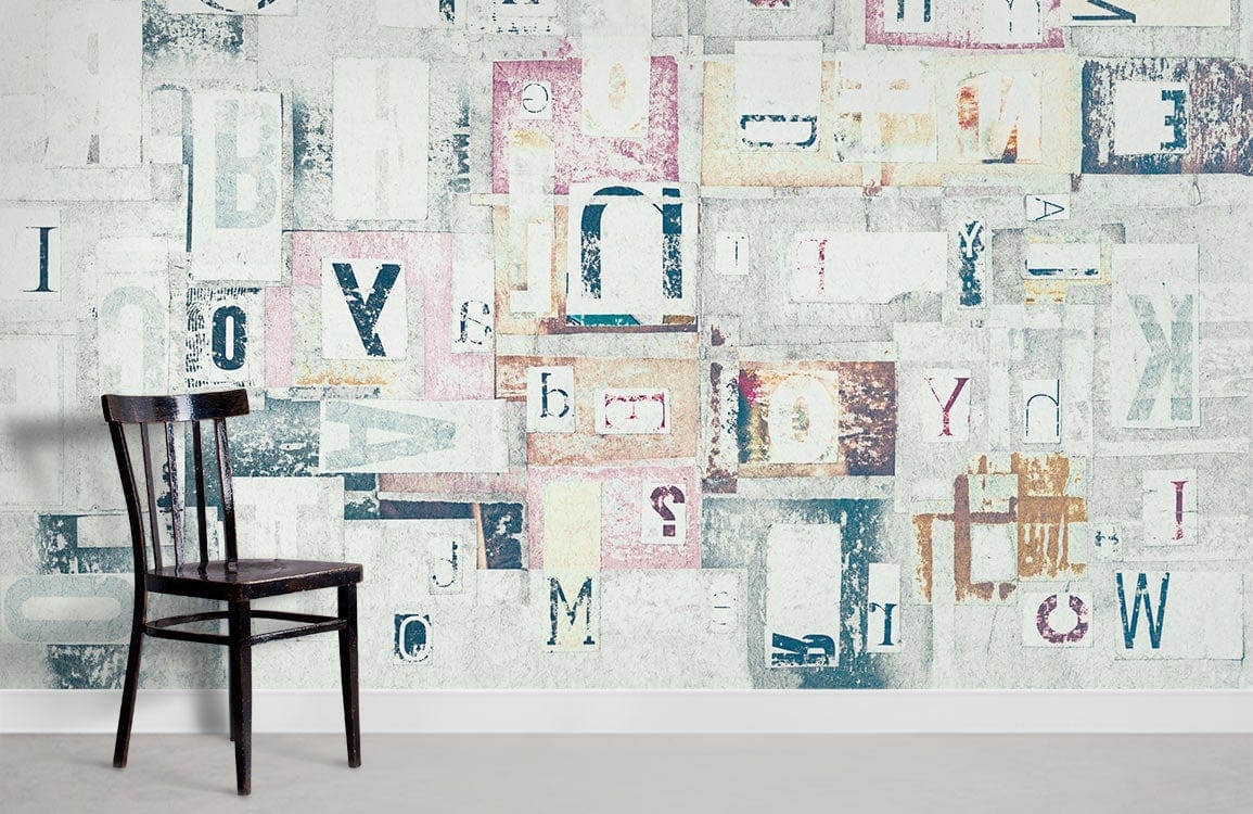 Vintage Letters Collage Mural Wallpaper in pastel tones with a dark wooden chair, grey flooring.