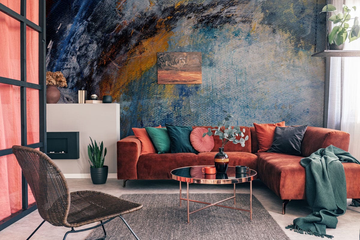 Modern living room with abstract blue and orange mural wallpaper, orange sofa, and grey flooring.