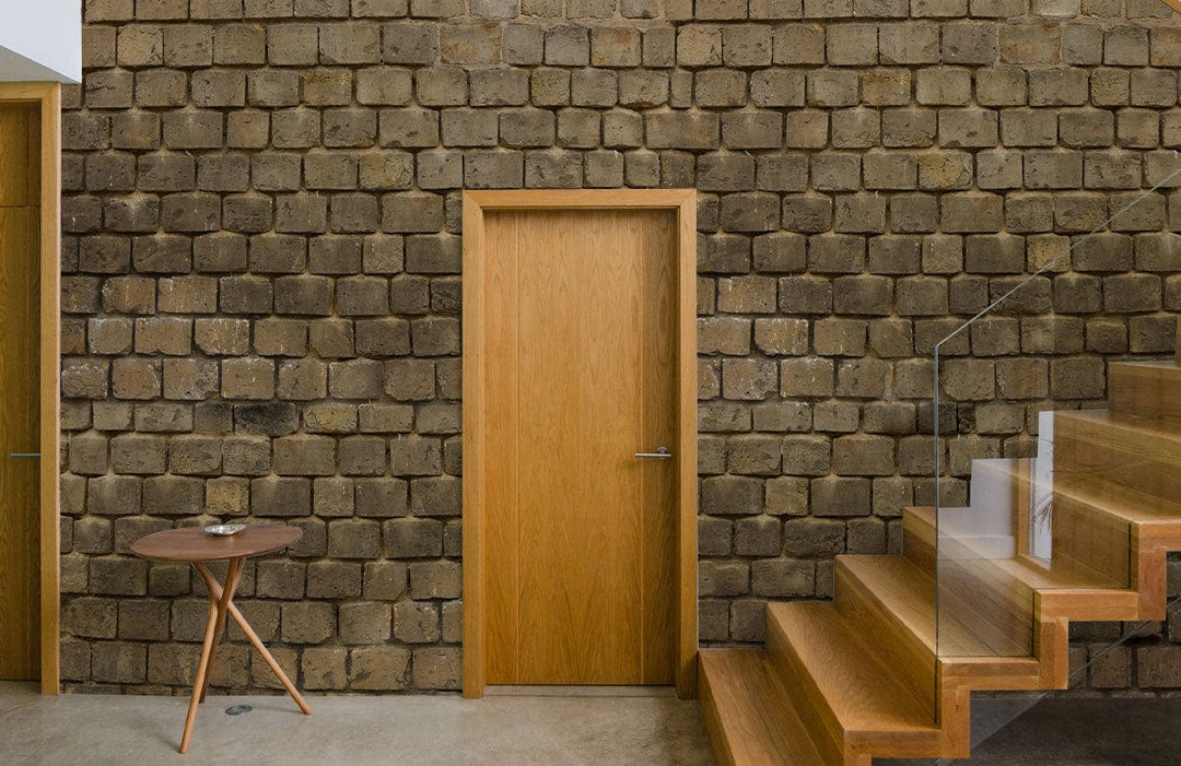 Rustic stone wall wallpaper in earthy brown tones, wooden staircase, oak door, modern interior design.