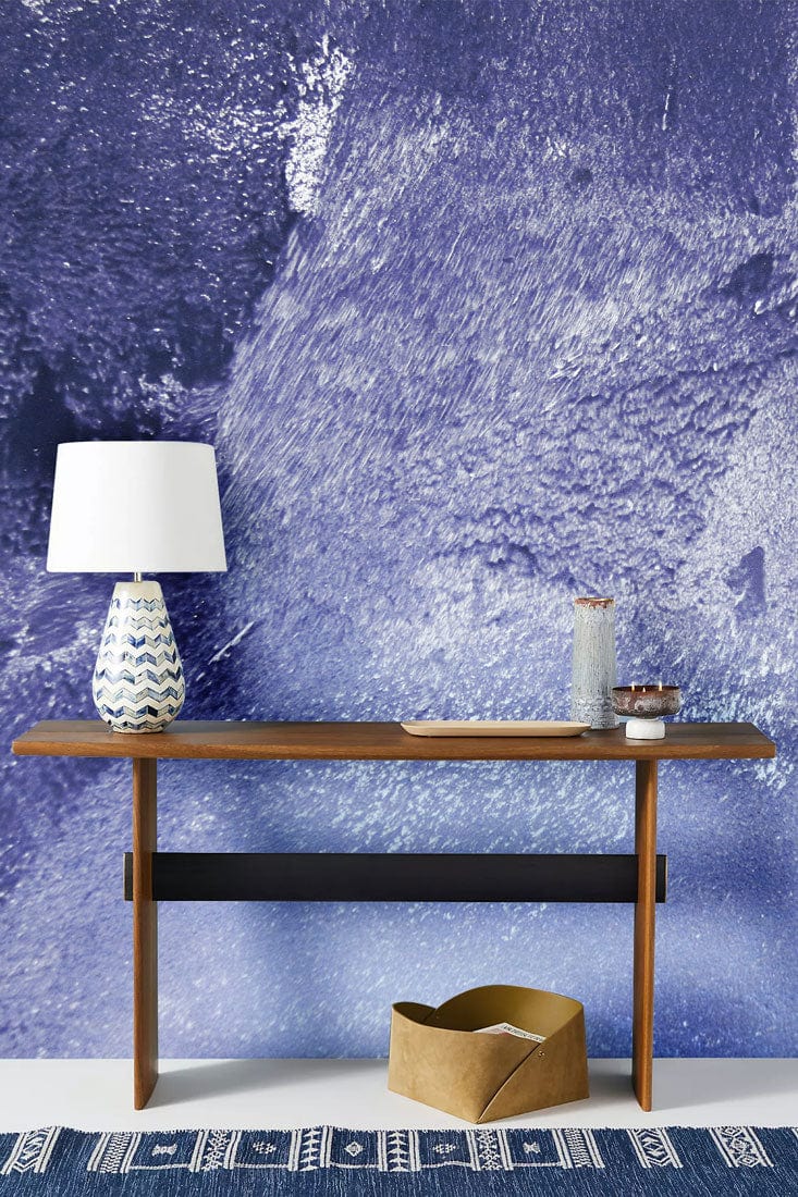 Abstract Textured Blue Mural Wallpaper with wooden console table, stylish lamp, and patterned blue rug.
