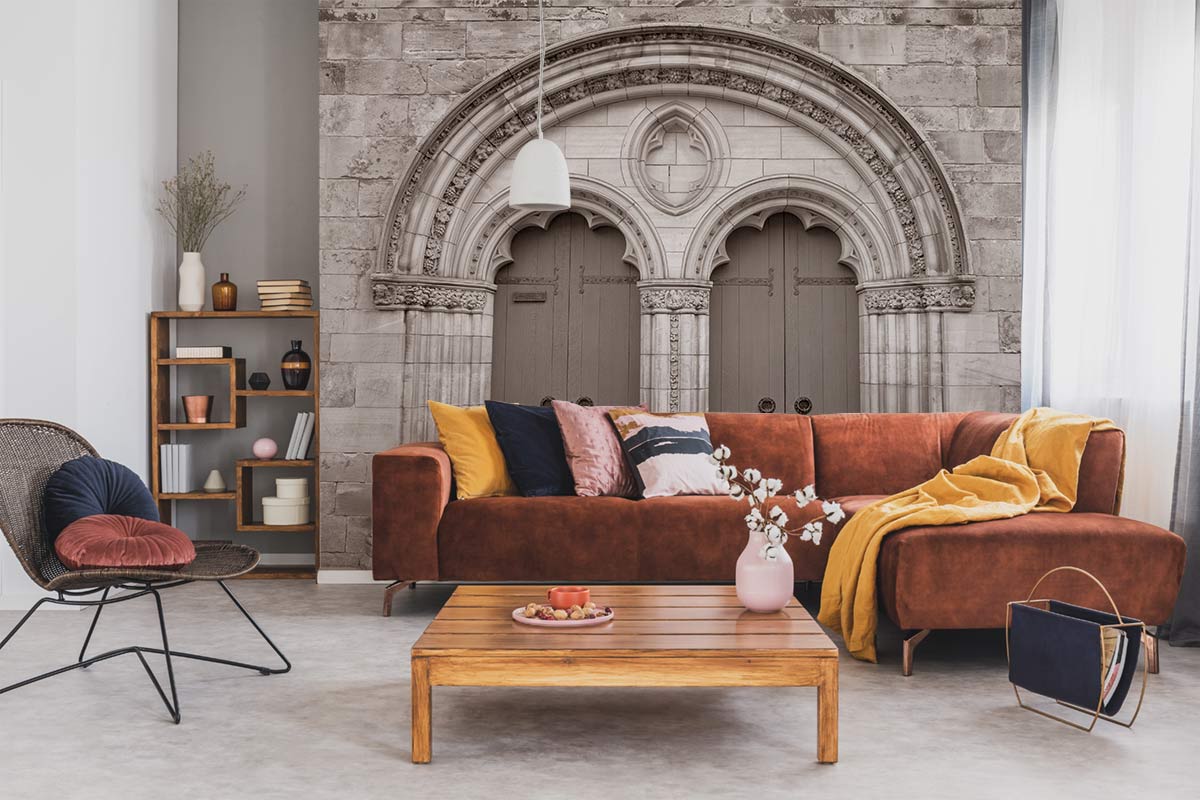 Vintage mural wallpaper in sepia, classic archway, brown velvet sofa, wooden coffee table, modern chair.