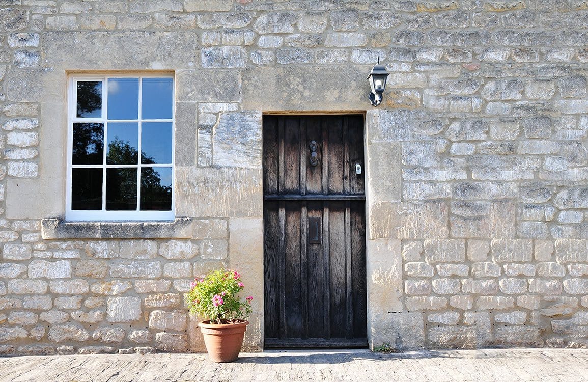 Rustic Stone Cottage Wall Mural with Wooden Door and Window