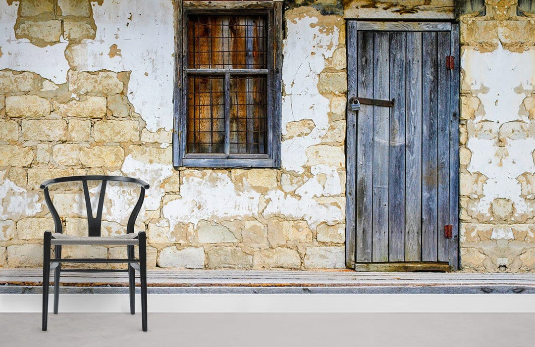 Rustic Stone Cottage Wall Mural with Weathered Door, wooden chair, beige flooring, vintage interior style.