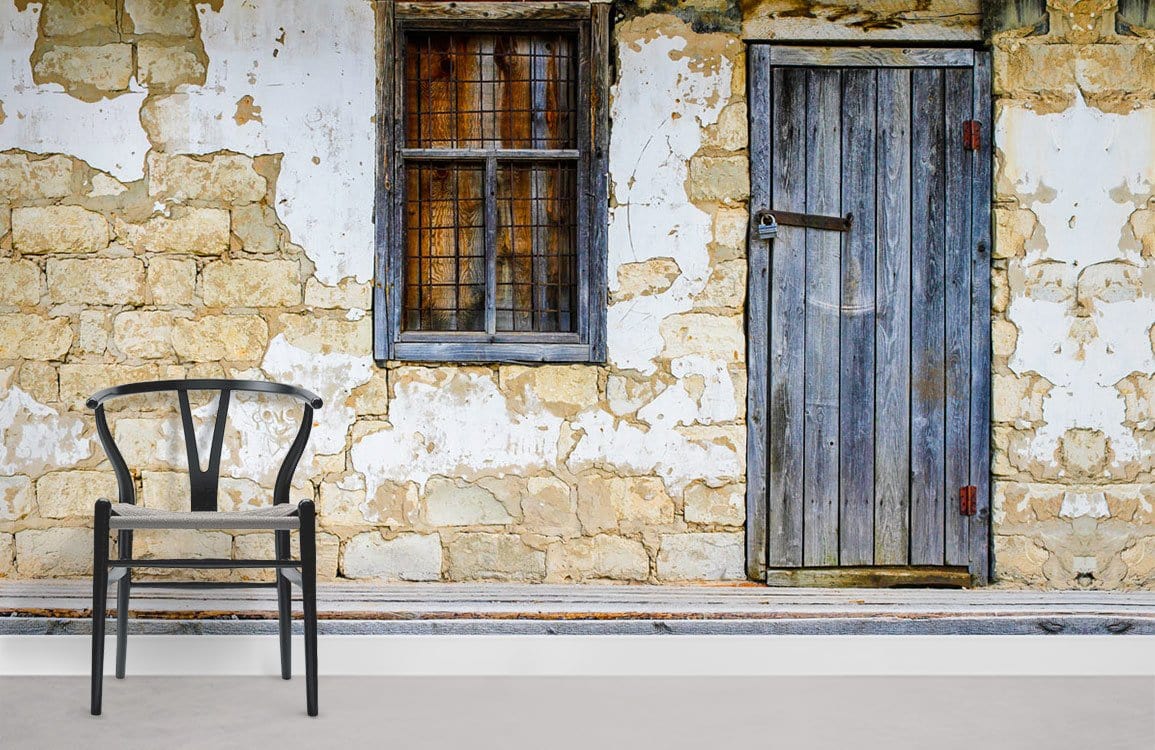 Rustic Stone Cottage Wall Mural with Weathered Door, wooden chair, beige flooring, vintage interior style.