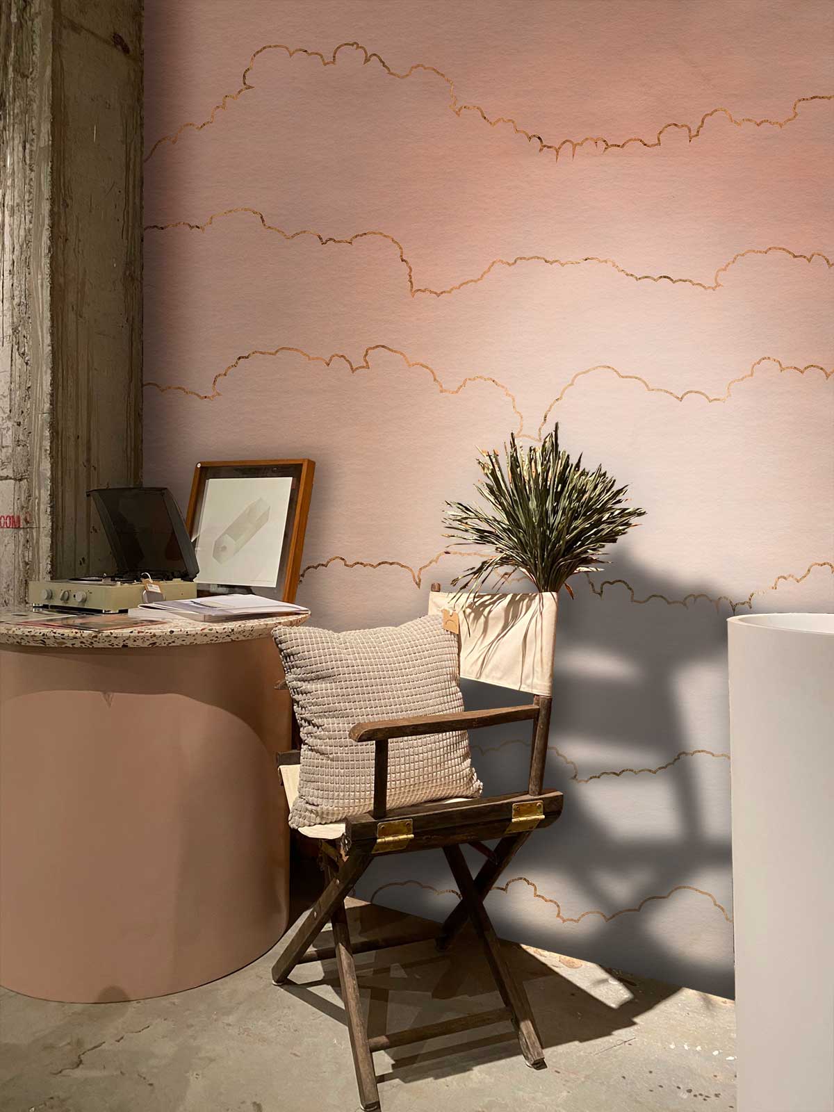 Elegant pastel pink cloud wallpaper in cosy room with wooden chair and round side table.