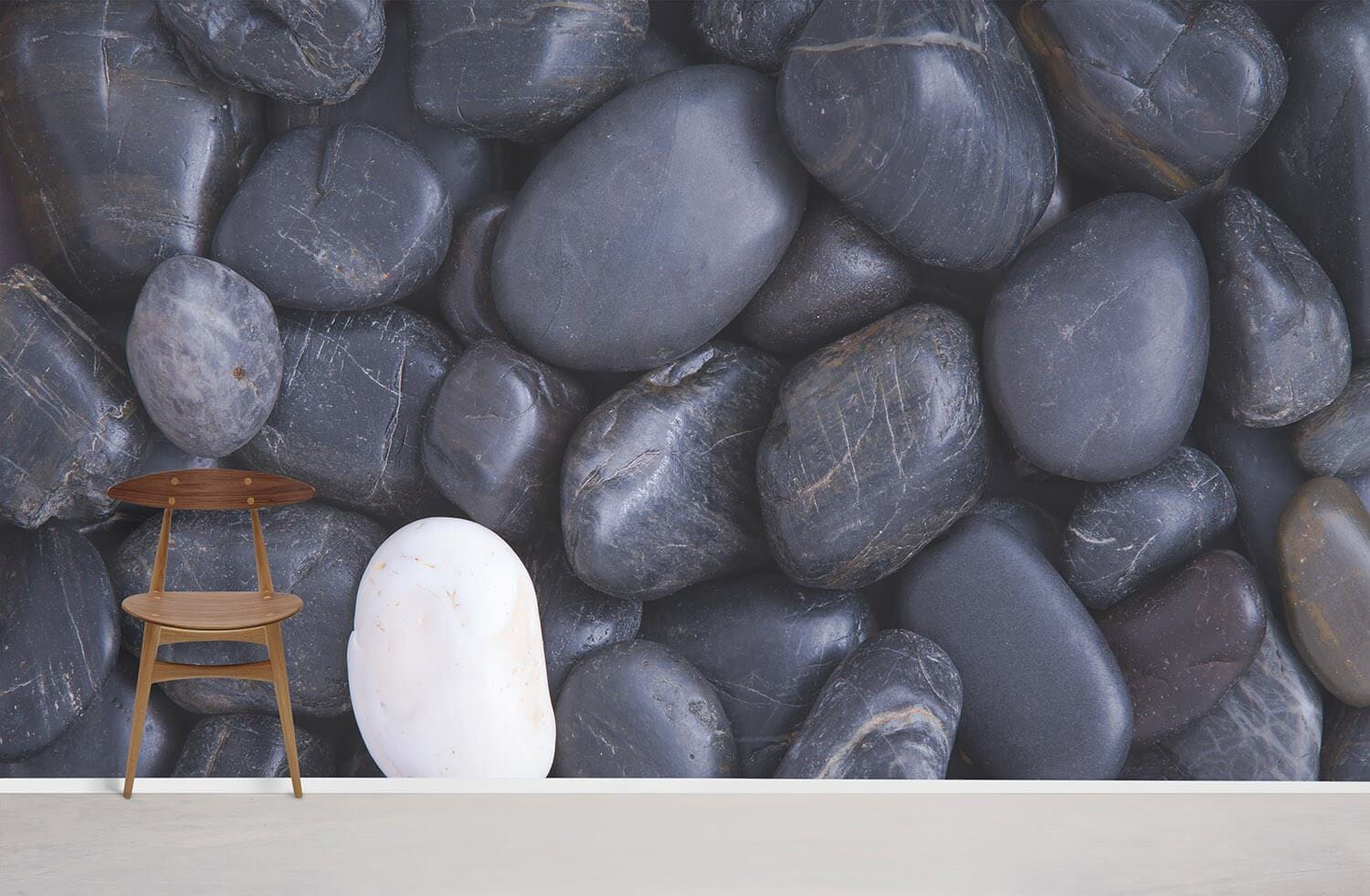 Grey pebble stone mural wallpaper; modern chair; white walls; minimalistic decor; contemporary design.