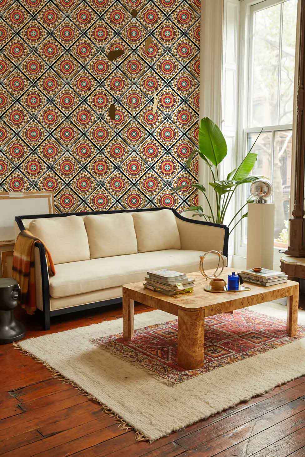 Retro Geometric Floral Wallpaper, vibrant red and yellow, cosy room, beige sofa, wooden flooring, plant.