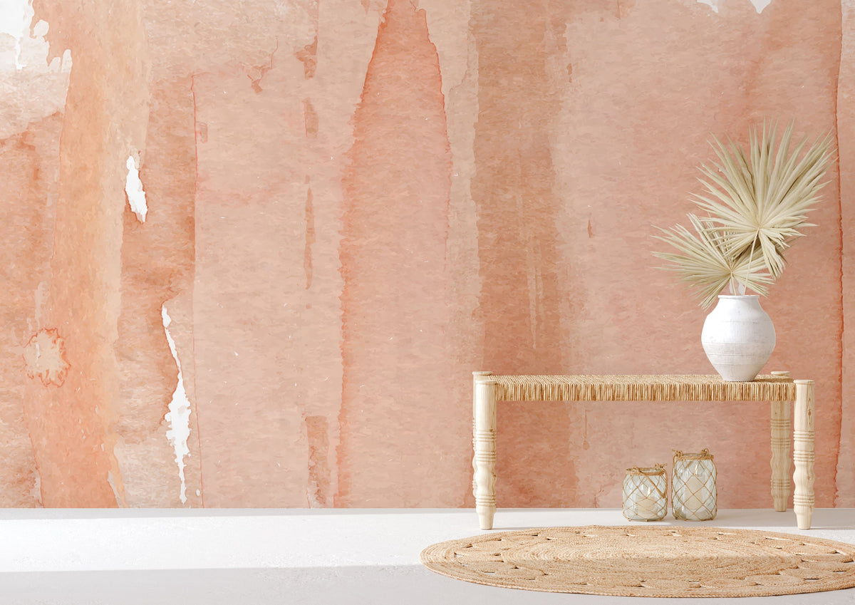 Peach watercolour mural wallpaper in modern room, natural wood table, vase, and neutral decor accents.