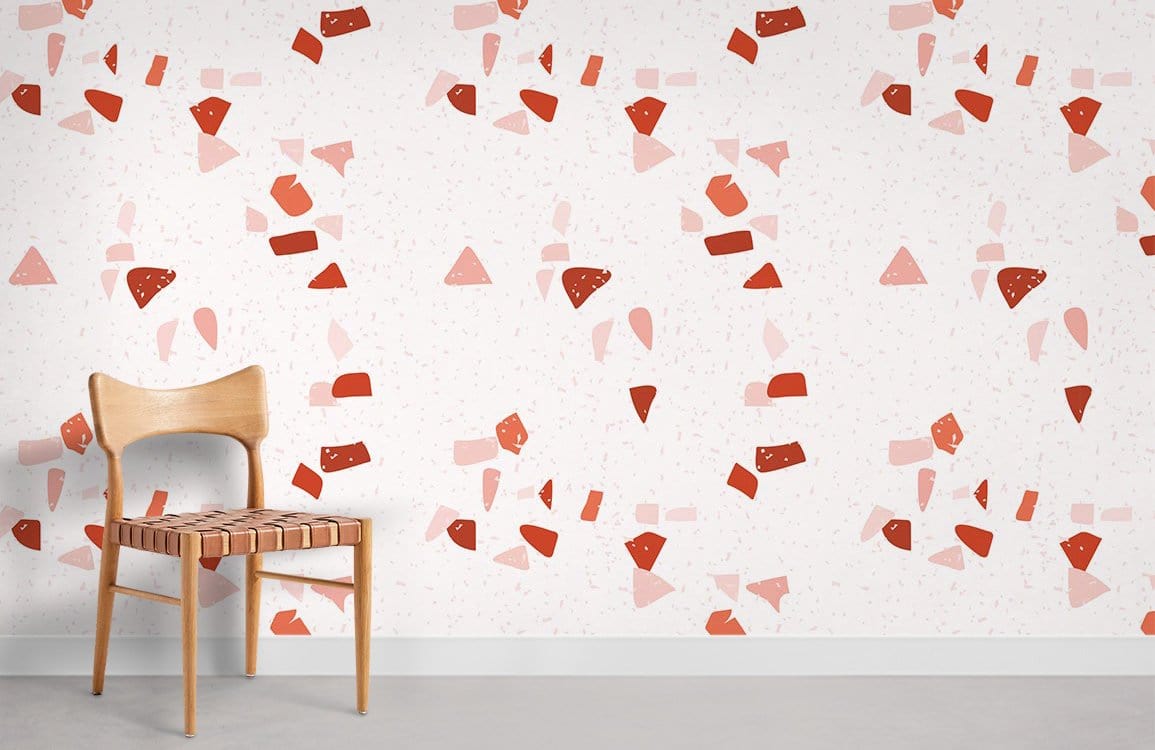 Red and pink geometric wallpaper with wooden chair, grey flooring, modern abstract design in bright tones.