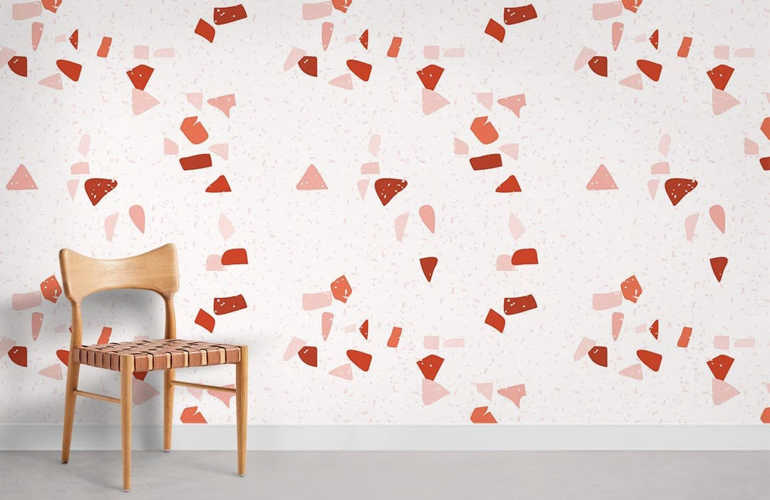 Red and pink geometric wallpaper with wooden chair, grey flooring, modern abstract design in bright tones.