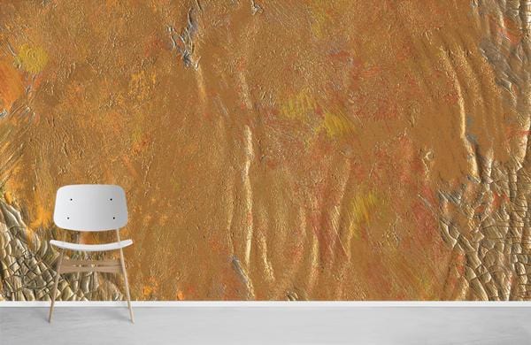 Golden textured abstract mural wallpaper with warm earthy tones, minimalist white chair, grey flooring.