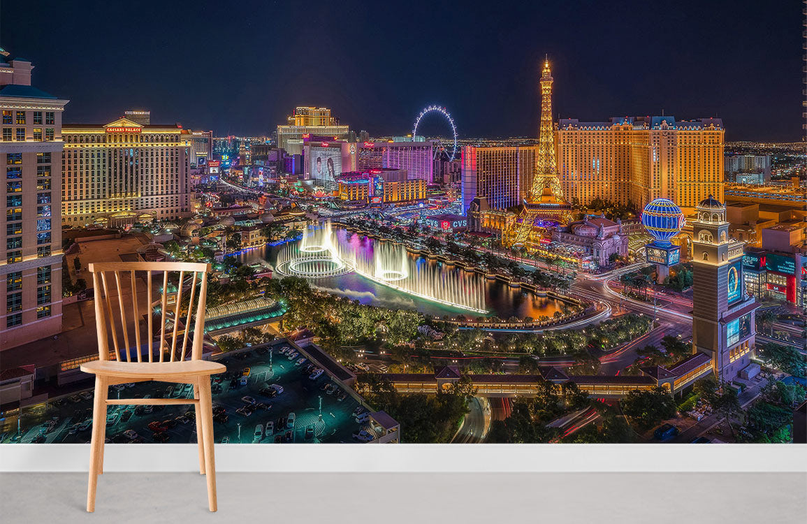 Vibrant Las Vegas skyline mural with colourful lights, wooden chair, light grey room, white skirting.